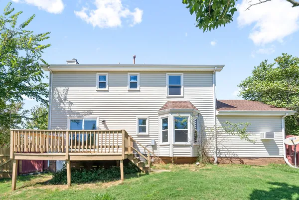 a porch with a bench next to a yard