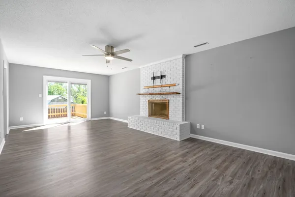 an empty room with windows and a fireplace