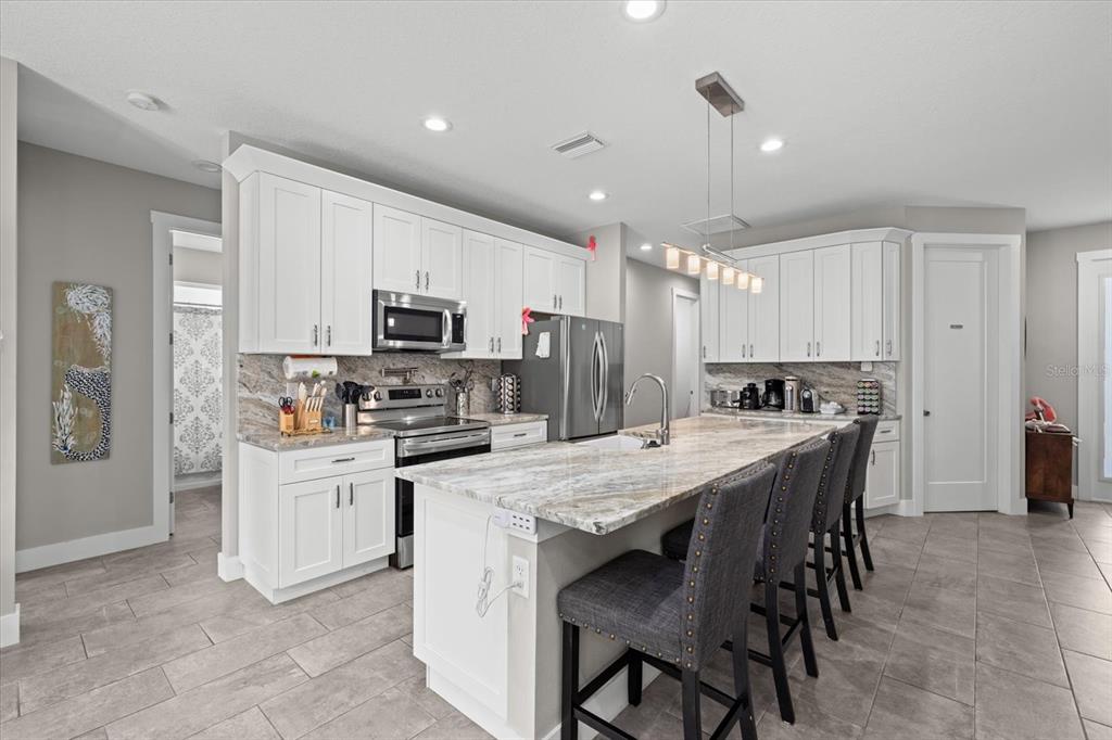 279 Avalon Road Venice, FL 34293 - Photo 17 of 32 a kitchen with kitchen island a dining table chairs stainless steel appliances and cabinets