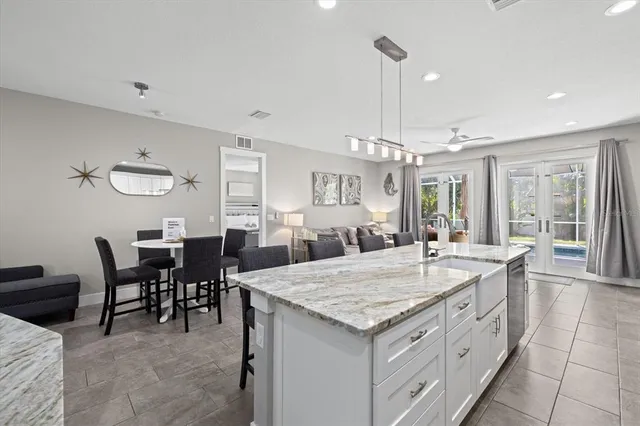 a large kitchen with kitchen island a sink table and chairs