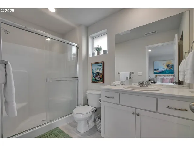 a bathroom with a sink a toilet a mirror and shower