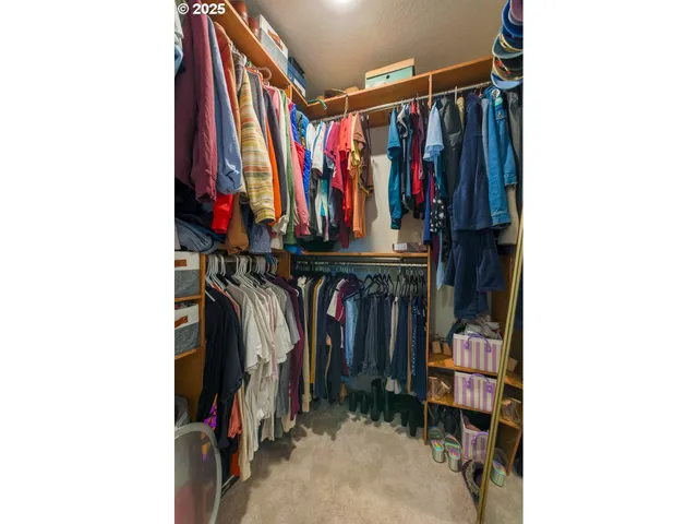 a view of walk in closet with clothes and shoes
