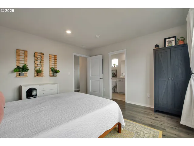 a spacious bedroom with a bed and wooden floor