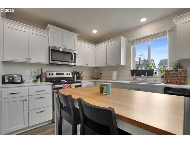 a kitchen with kitchen island granite countertop a sink counter top space appliances and cabinets