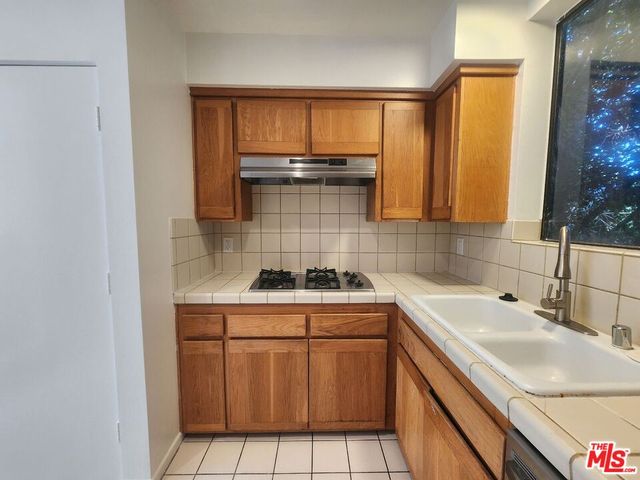 a kitchen with a sink stove and cabinets