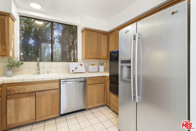 a kitchen with stainless steel appliances a sink stove and refrigerator