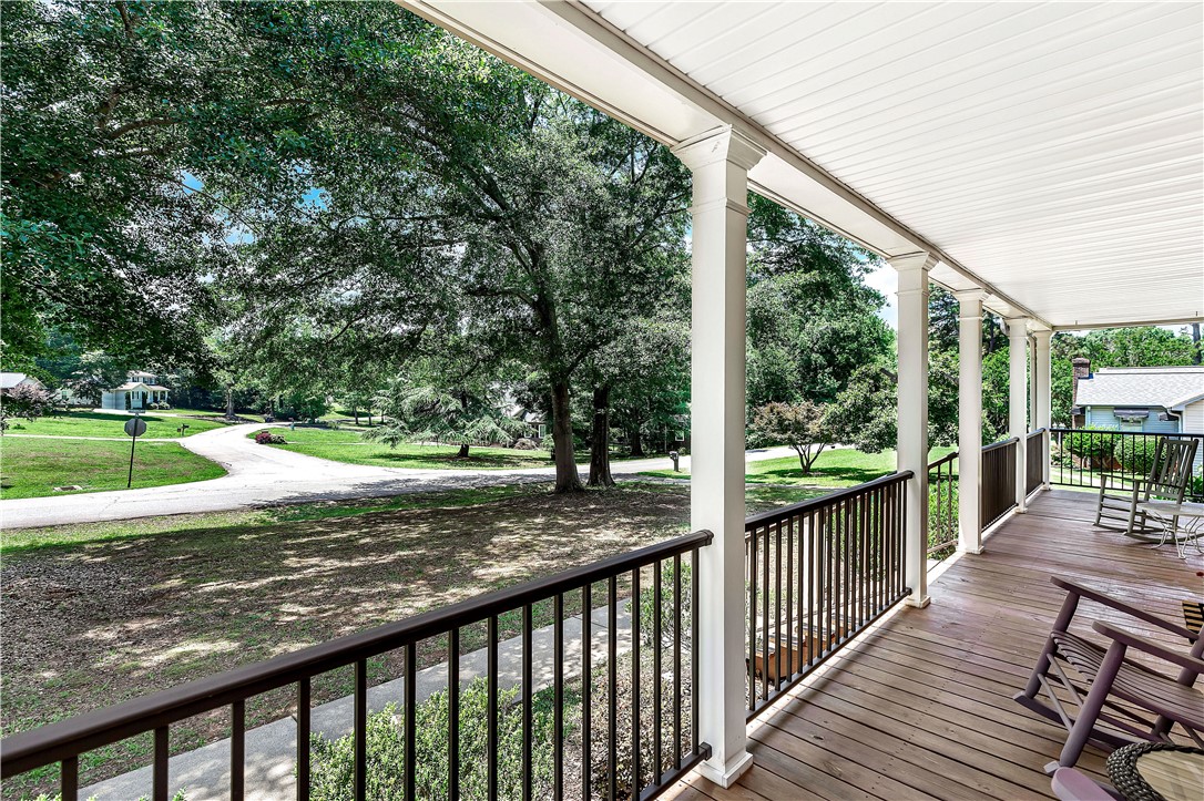 910 Chantilly Lane Anderson, SC 29625 - Photo 4 of 38 Relax on the expansive wooden porch, offering serene views of the verdant front yard and winding driveway.