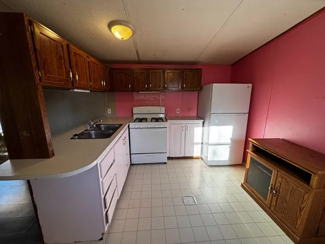 a kitchen with wooden cabinets stove top oven and sink