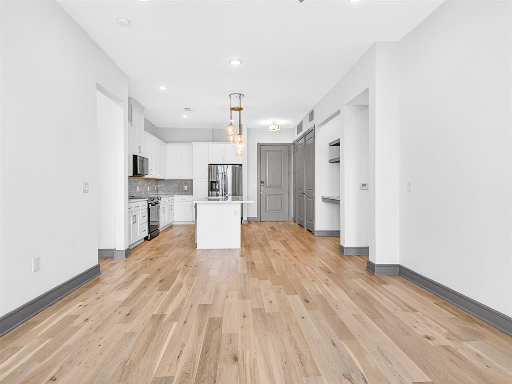 2700 Old Denton Road, Unit 4440 Carrollton, TX 75007 - Photo 11 of 32 Open concept living space featuring light wood-finish flooring, recessed lighting, and a modern kitchen