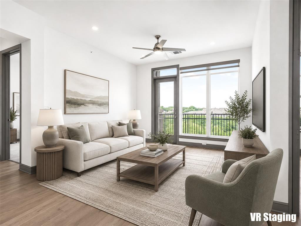 2700 Old Denton Road, Unit 4440 Carrollton, TX 75007 - Photo 12 of 32 Living area with wood-finish flooring and a full-light glass door opening to an exterior balcony