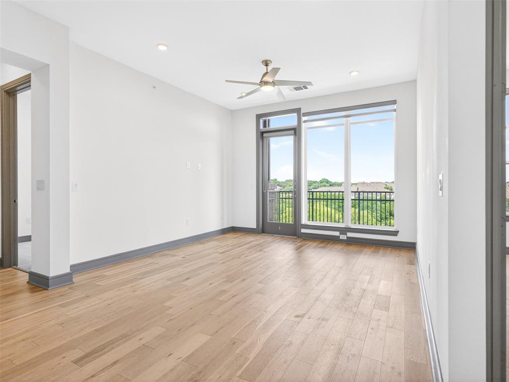 2700 Old Denton Road, Unit 4440 Carrollton, TX 75007 - Photo 13 of 32 Spacious room featuring wood-finish flooring, a ceiling fan, recessed lighting, and balcony access through a glass-paneled door