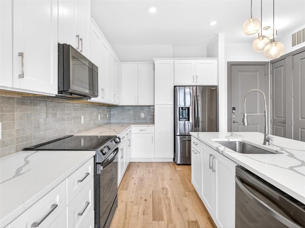 2700 Old Denton Road, Unit 4440 Carrollton, TX 75007 - Photo 8 of 32 Kitchen featuring white shaker-style cabinetry, quartz countertops with veining, and a subway tile backsplash
