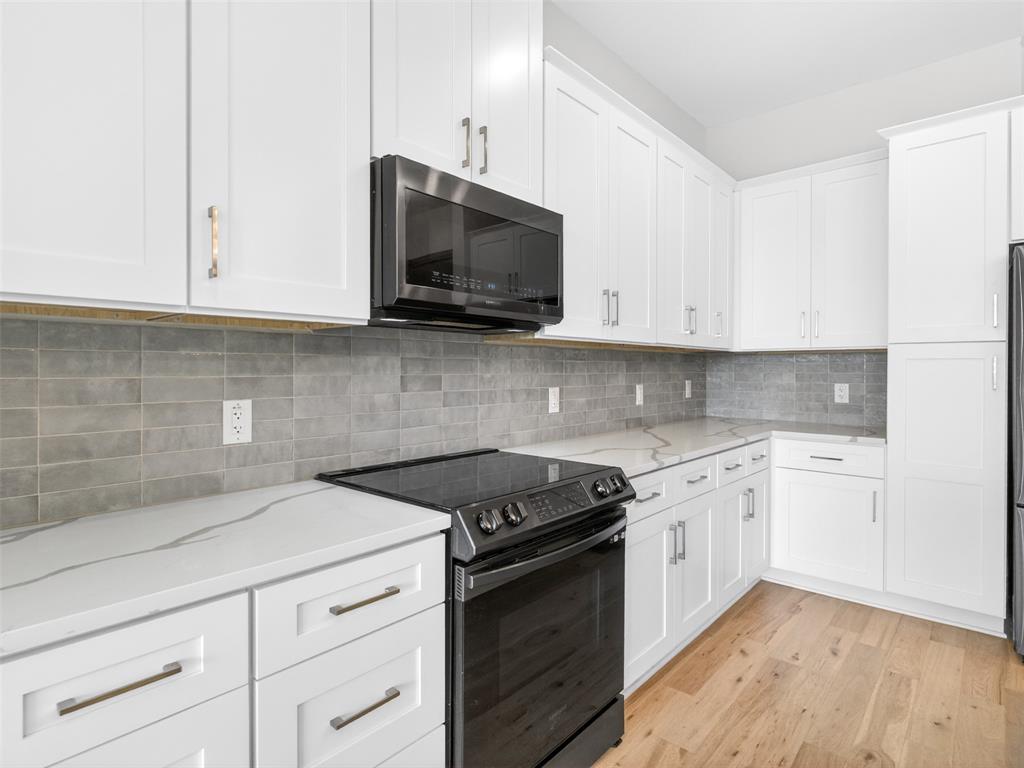 2700 Old Denton Road, Unit 4440 Carrollton, TX 75007 - Photo 9 of 32 Kitchen featuring white shaker cabinetry, patterned solid surface countertops, a mosaic tile backsplash, and light wood-finish flooring