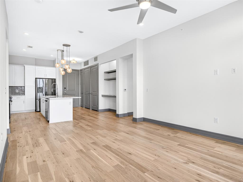 2700 Old Denton Road, Unit 4440 Carrollton, TX 75007 - Photo 10 of 32 Open-concept living area with wood-finish flooring, a contemporary kitchen, and a ceiling fan