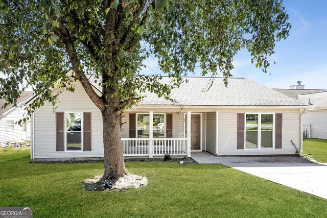 a front view of a house with a garden and yard
