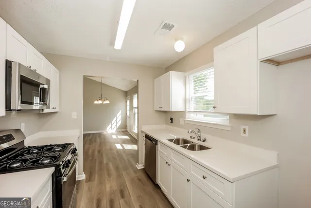 a kitchen with a sink stove and cabinets