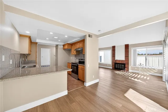 a large living room with stainless steel appliances granite countertop a couch and wooden floor