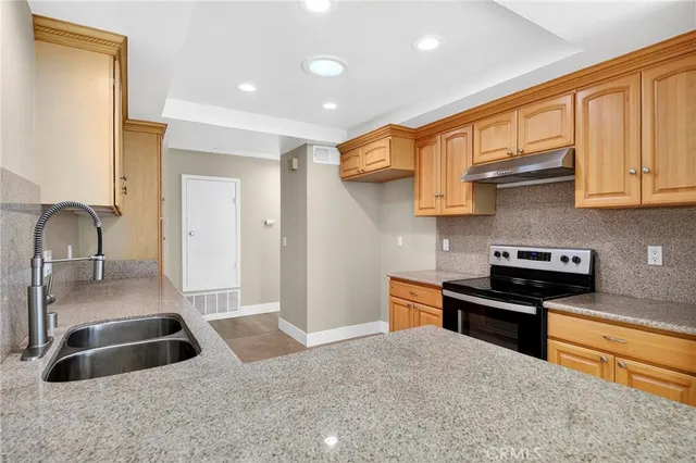 a kitchen with granite countertop a sink stainless steel appliances and cabinets