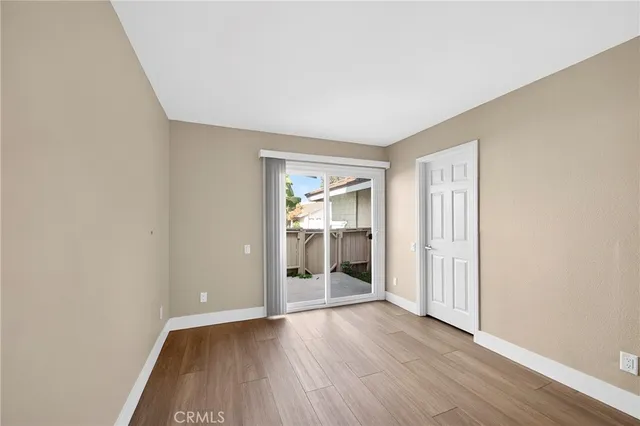 an empty room with wooden floor & window
