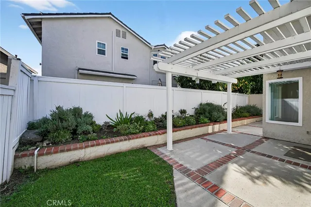 a front view of a house with a yard and potted plants