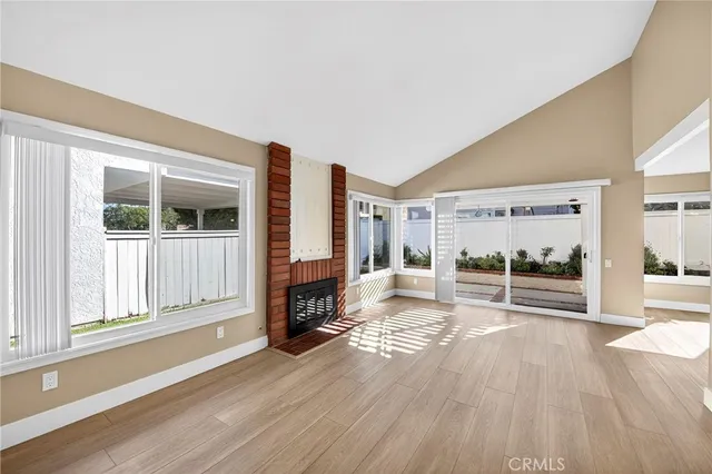 a view of a livingroom with wooden floor and a fireplace