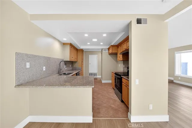 a view of kitchen island a sink a refrigerator and a window