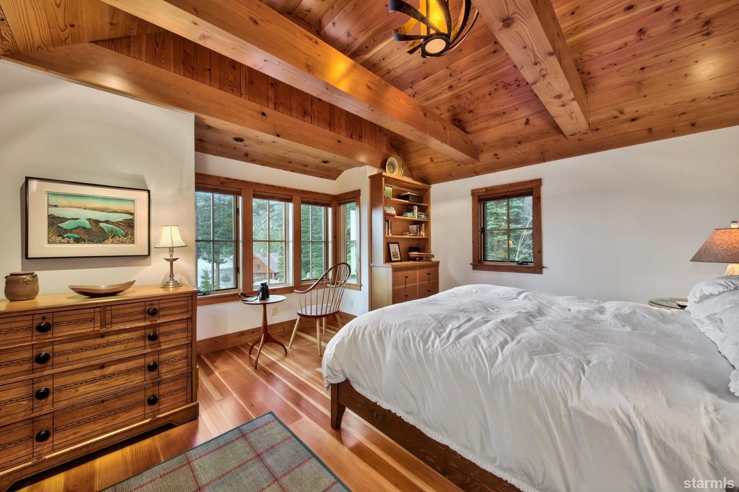 373 Fallen Leaf Road Fallen Leaf, CA 96150 - Photo 14 of 40 a spacious bedroom with a bed a dresser and a chandelier