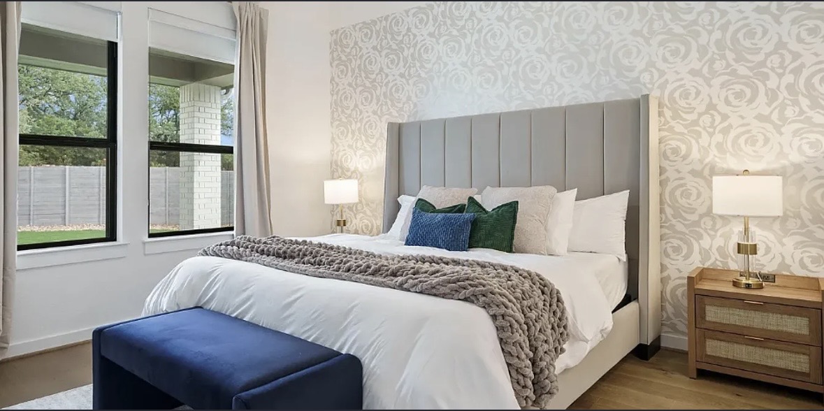 109 Arrowhead Mound Road Georgetown, TX 78628 - Photo 19 of 27 A tranquil bedroom retreat features a chic padded headboard and patterned accent wall, offering a serene escape.
