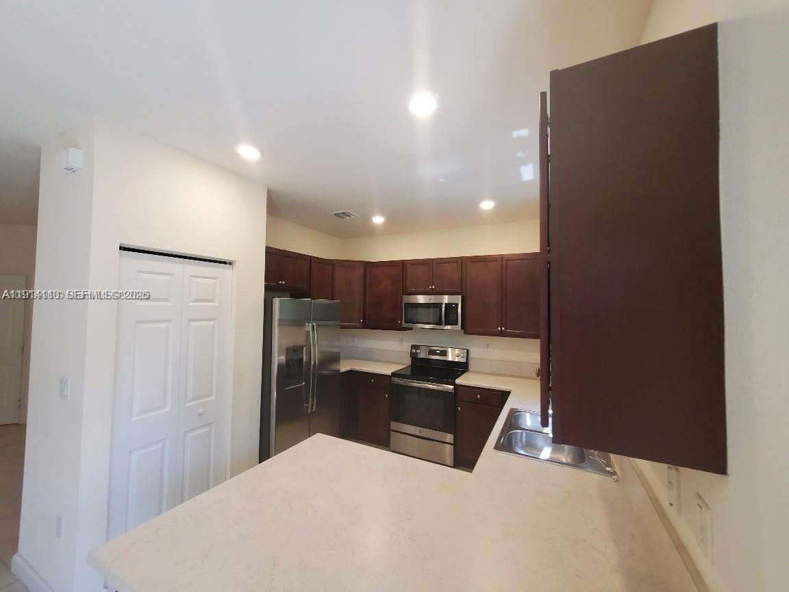 110 Southeast 33rd Terrace Homestead, FL 33033 - Photo 3 of 11 a kitchen with stainless steel appliances a refrigerator sink and microwave