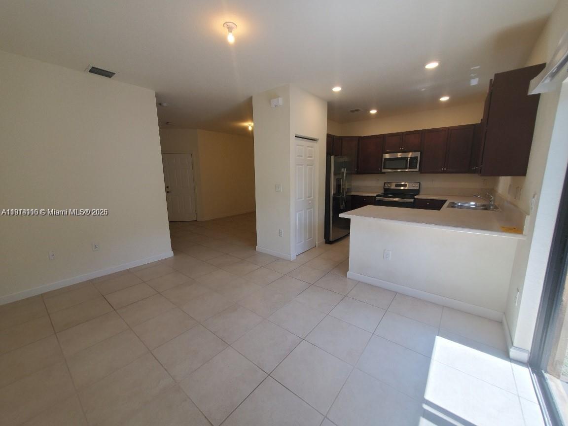 110 Southeast 33rd Terrace Homestead, FL 33033 - Photo 6 of 6 a view of a kitchen with a sink and a refrigerator