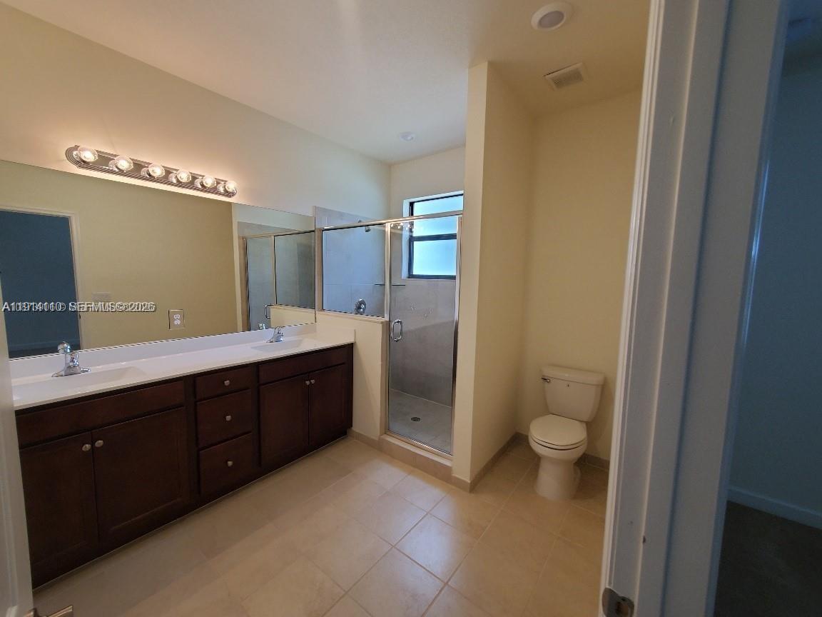110 Southeast 33rd Terrace Homestead, FL 33033 - Photo 6 of 11 a spacious bathroom with a double vanity sink a toilet and a mirror
