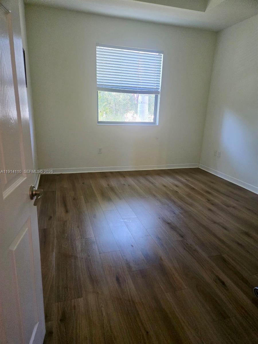 110 Southeast 33rd Terrace Homestead, FL 33033 - Photo 10 of 11 an empty room with wooden floor and windows
