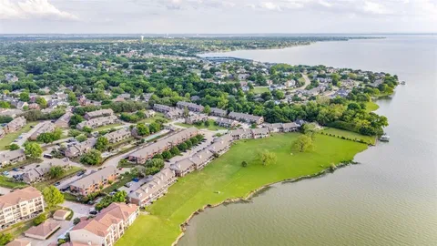 an aerial view of a house with a yard and lake view