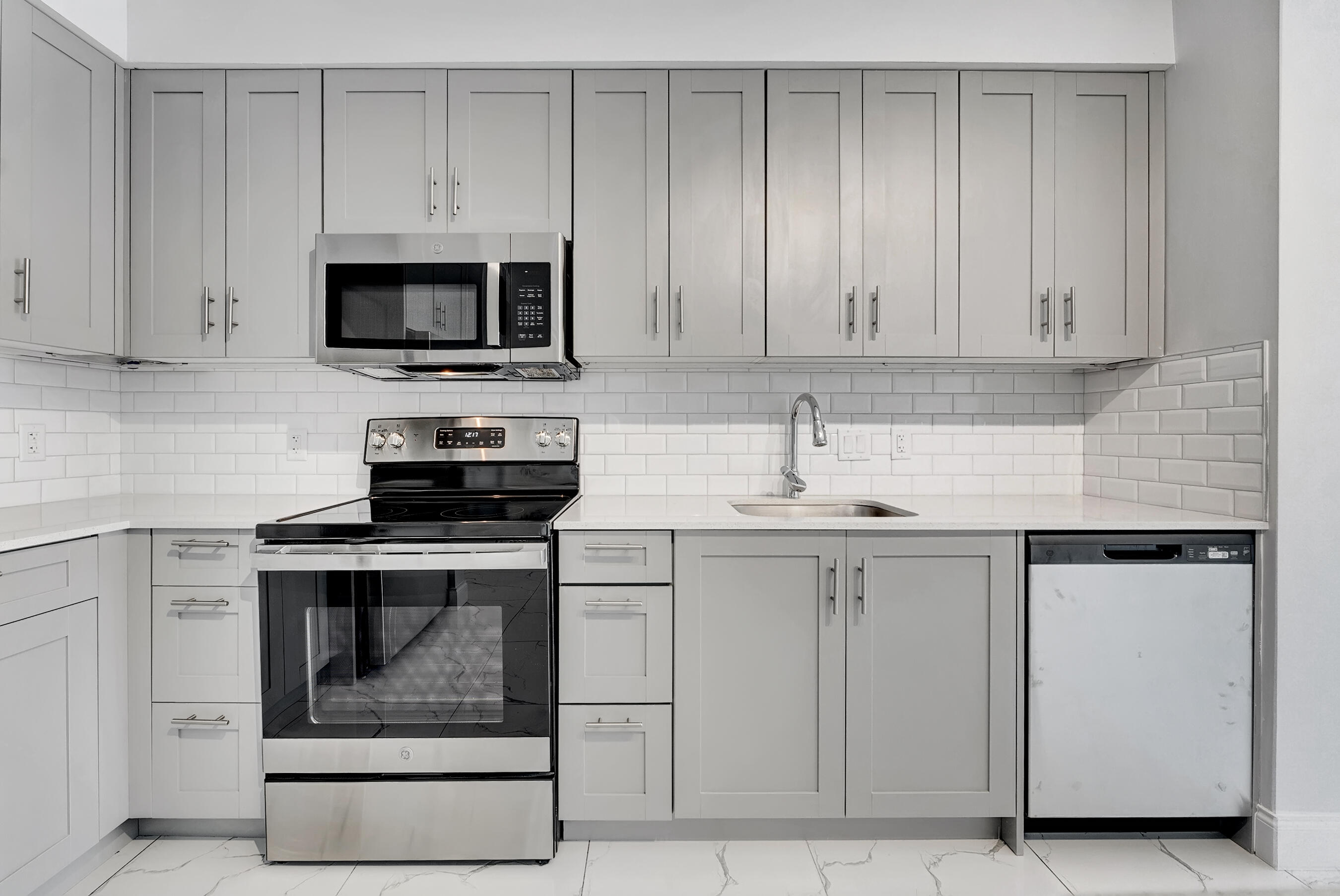 250 West Hidden Valley Boulevard, Unit 2 Boca Raton, FL 33487 - Photo 5 of 19 a kitchen with white cabinets and stainless steel appliances