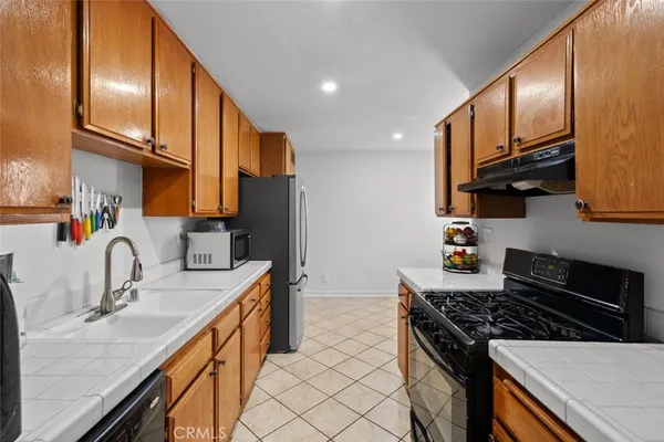 a kitchen with stainless steel appliances a sink stove and refrigerator
