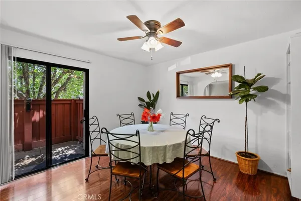 a dining room with furniture potted plants and wooden floor