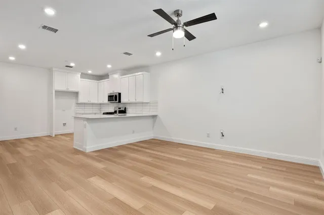 a view of kitchen with kitchen island stainless steel appliances sink and cabinets