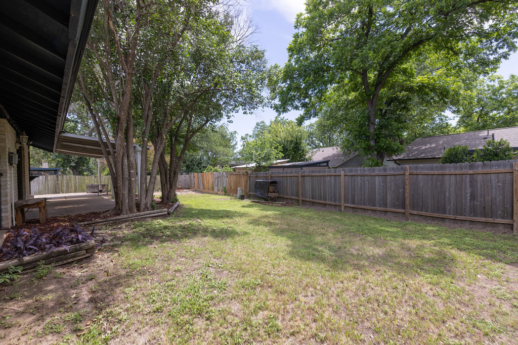 5310 Presidio Road Austin, TX 78745 - Photo 32 of 34 A spacious backyard with mature trees and privacy fencing defines this verdant property.