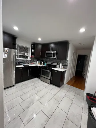 a kitchen with stainless steel appliances a sink a stove top oven a counter space and cabinets