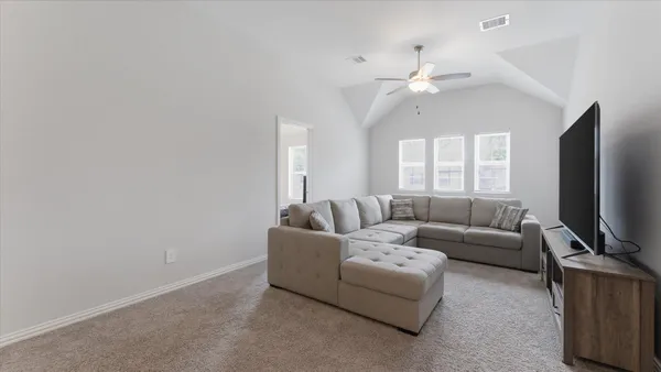 a living room with furniture a ceiling fan and a window