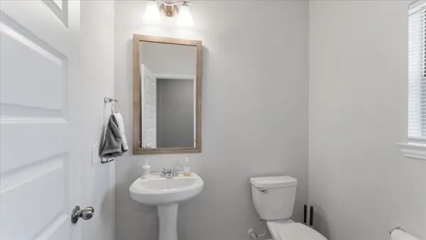 a bathroom with a toilet sink and mirror