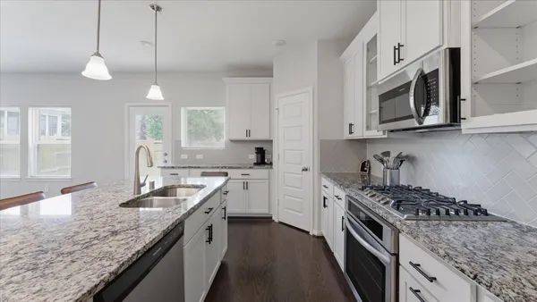 a kitchen with stainless steel appliances granite countertop a sink a stove oven a counter space and cabinets