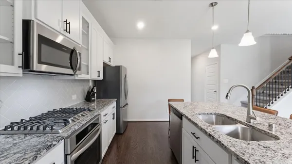 a kitchen with a sink stove and microwave