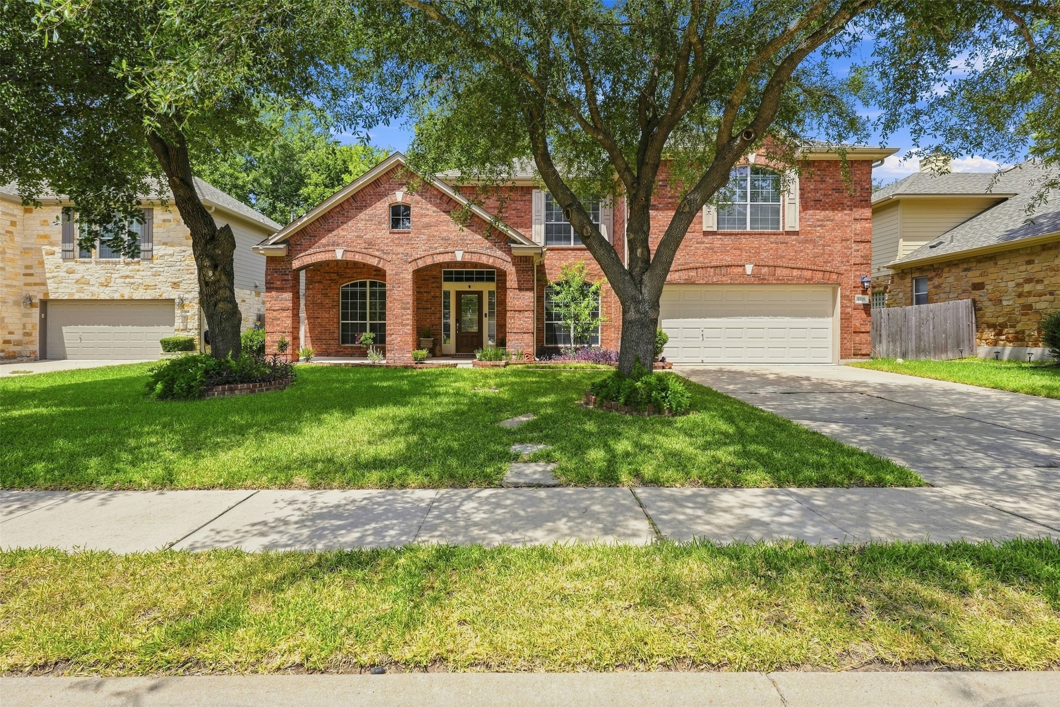 Mature shade trees frame the classic brick exterior of this elegant two-story residence.