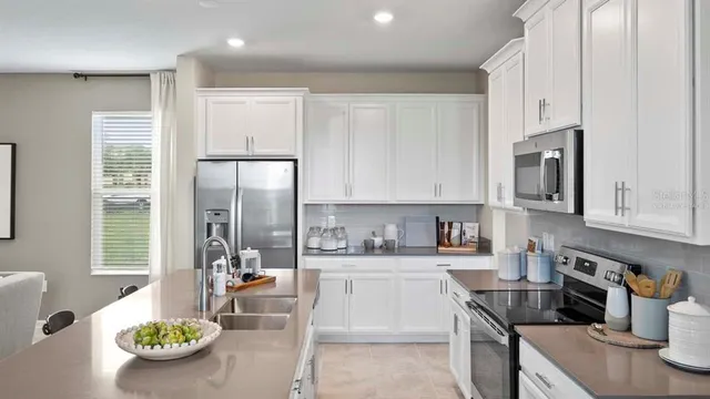a kitchen with stainless steel appliances a stove a sink and a refrigerator