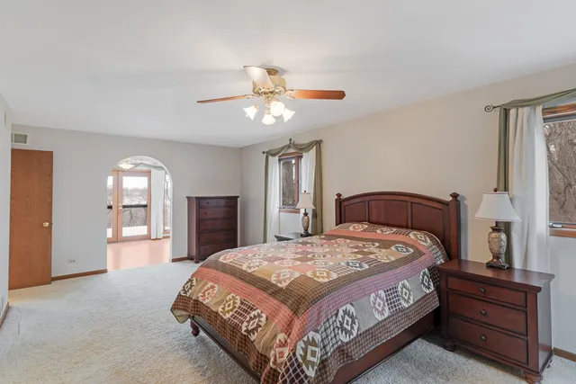 a bedroom with a large bed and a chandelier