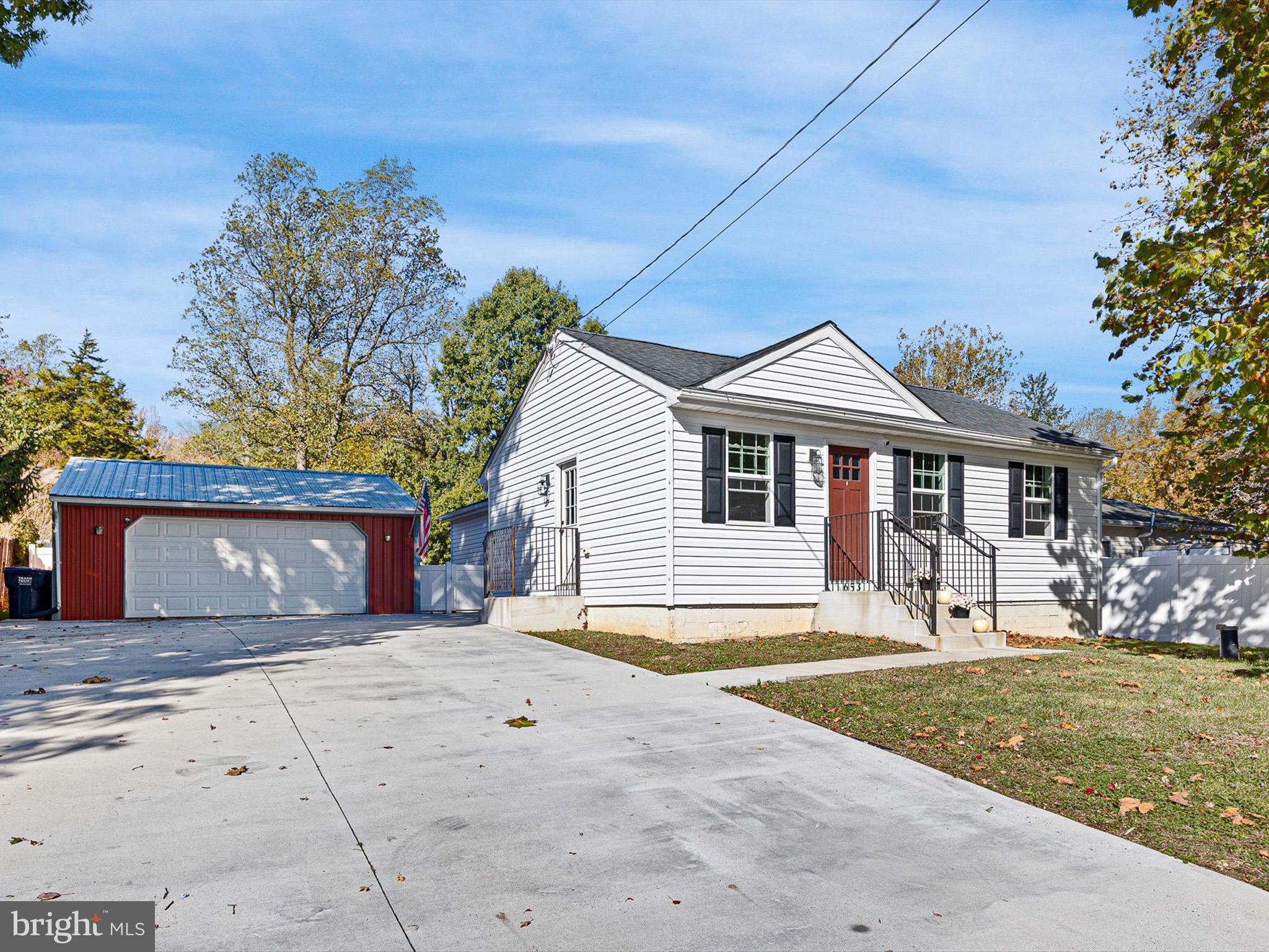 a front view of a house with a garden and trees