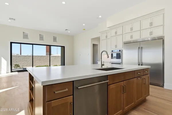 a kitchen with stainless steel appliances sink cabinets and window