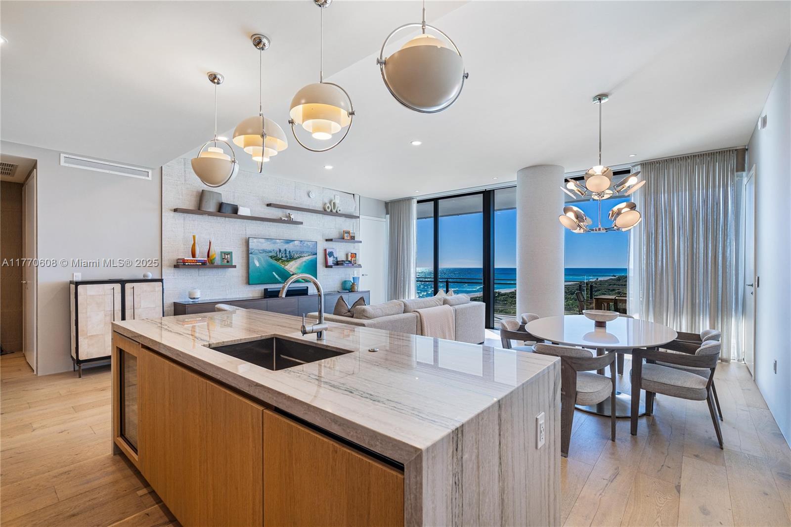 8701 Collins Avenue, Unit 804 Miami Beach, FL 33154 - Photo 11 of 25 a kitchen with a table chairs and a chandelier