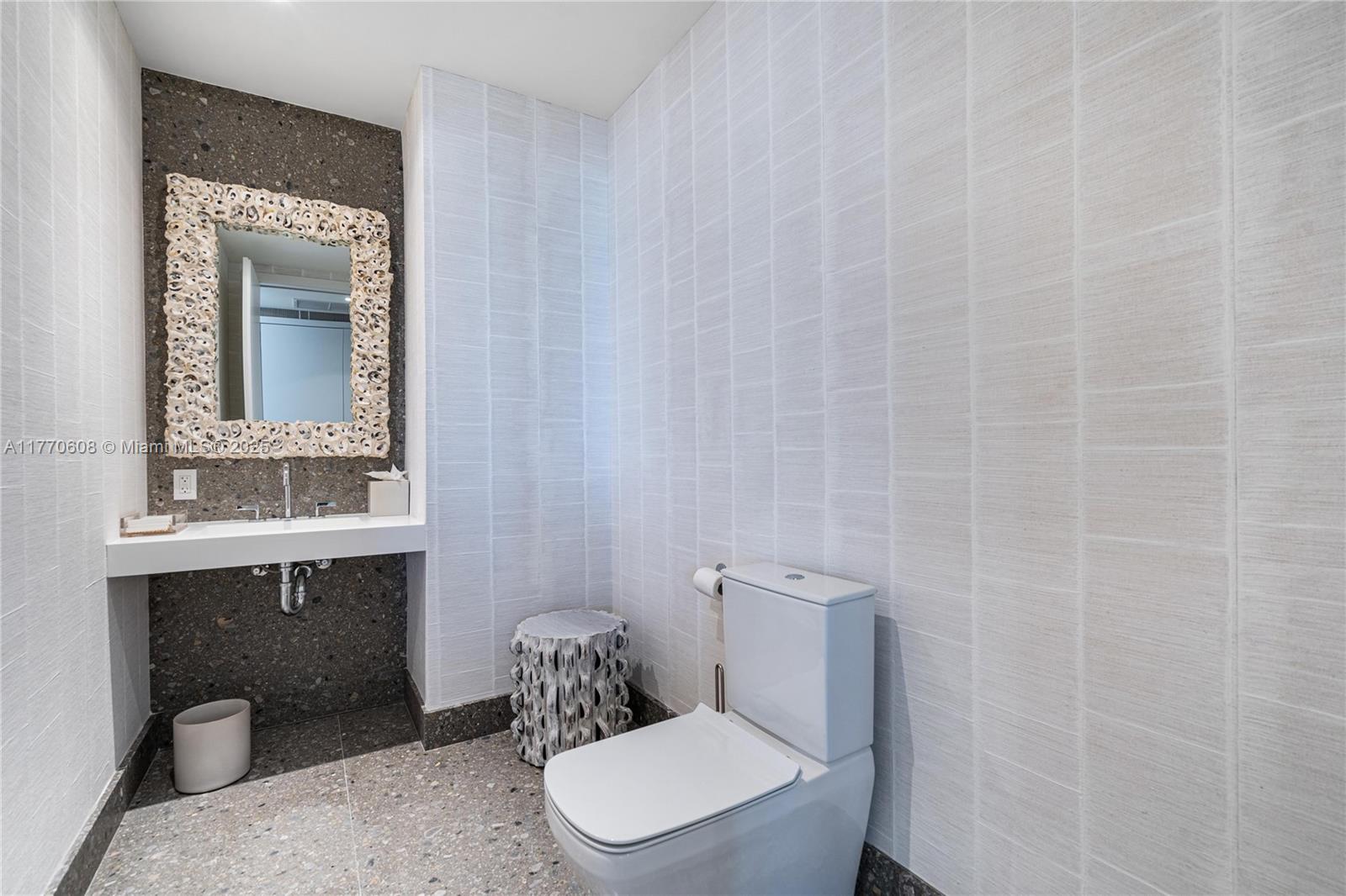 8701 Collins Avenue, Unit 804 Miami Beach, FL 33154 - Photo 14 of 25 a bathroom with a toilet a sink and mirror